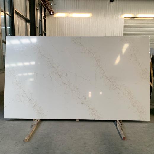 Losas de cuarzo blanco con vetas doradas, fabricadas industrialmente.